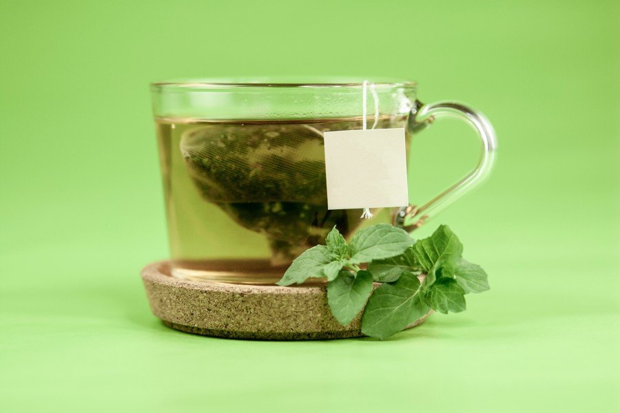 Freshly brewed premium herbal tea in a glass cup with mint leaves for natural wellness and immunity support